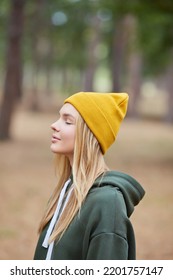 Closeup portrait of gorgeous young blonde Caucasian woman in knitted beanie in autumn in park. Young woman head shot, natural light, retouched, vibrant colors.