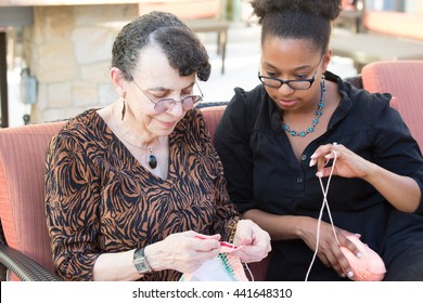 Closeup portrait, granddaughter and grandmother sitting, enjoying time together, isolated outdoors background