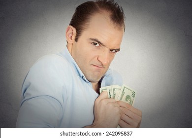 Closeup Portrait Greedy Banker Executive CEO Boss, Corporate Employee Funny Looking Man Holding Dollar Banknotes Scared To Loose Money, Suspicious Isolated Grey Background. Human Face Expression