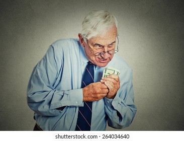 Closeup Portrait Greedy Senior Executive, CEO, Boss, Old Corporate Employee, Mature Man, Holding Dollar Banknotes Isolated On Gray Wall Background. Negative Human Emotion Facial Expression
