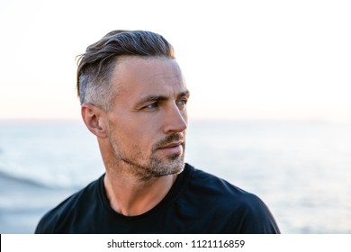 Close-up Portrait Of Handsome Adult Man With Grey Hair Looking Away On Seashore