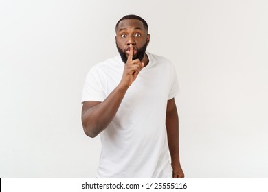 Closeup portrait of handsome bald man placing finger on lips as if to say,shhhhh,be quiet,silence. Isolated on white background with copy space.