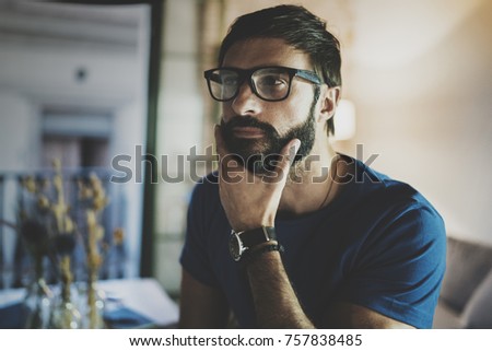 Closeup portrait of Handsome bearded man spending rest time at the modern home at evening.Horizontal. Blurred background
