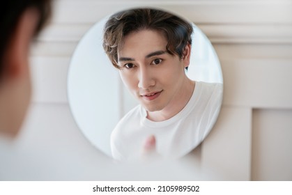 Closeup Portrait Of Handsome Beautiful Asian Boy With Mirror Makeup Routine With Copy Space. Beauty Influencer Guy With Perfect Glow Skin Dress Up. Healthcare Man Lifestyle Cosmetic Blogger Concept