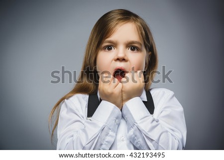 Closeup Portrait of handsome girl with astonished expression while standing against grey background