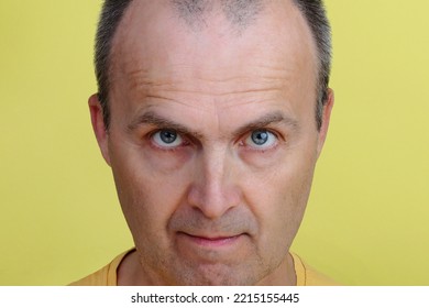 Close-up Portrait Of A Handsome Man 45-55 Years Old On A Yellow Background.