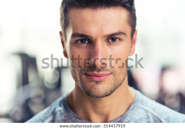 Closeup portrait of a\
handsome man at gym