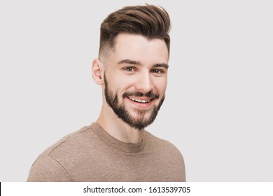 Close-up portrait of handsome smiling young man. Laughing joyful cheerful men studio shot. Isolated on gray background