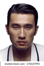 Close-up Portrait Of Handsome Young Chinese Man Wearing Black And White Suit And Looking At Camera. Color Image