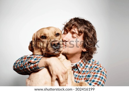 Closeup portrait handsome young hipster man, kissing his good friend dog isolated black grey background. Positive human emotions, facial expression, feelings.
