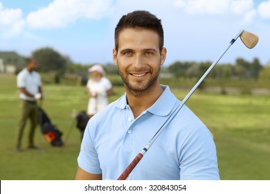 Closeup portrait of handsome young male golfer with golf club.