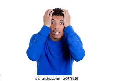 Closeup portrait of a handsome young man looking shocked, surprised in disbelief with hands on head looking at you camera, isolated on white background. Negative human emotions facial expressions