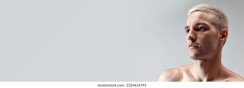 Close-up portrait of handsome young man with blonde hair, well-kept skin posing shirtless against grey studio background. Concept of male natural beauty, body care, health, sport, fashion. Banner. ad - Powered by Shutterstock