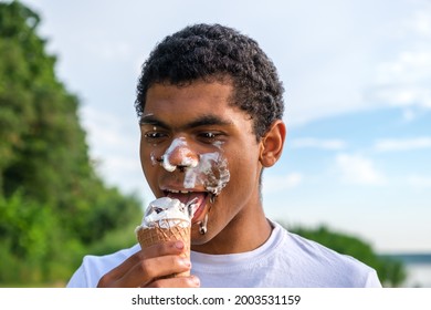 Close-up portrait of a happy African American man with melted ice cream on his face outdoors in summer. - Powered by Shutterstock