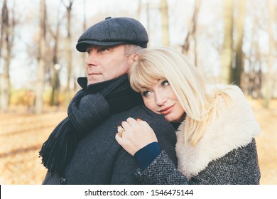 Closeup Portrait Of A Happy Blonde Mature Woman And Beautiful Middle-aged Brunette, Looking Away. Pensive, Dreamy Loving Couple Of 45-50 Years Old Walks In The Autumn Park In Warm Clothes, In A Coat 