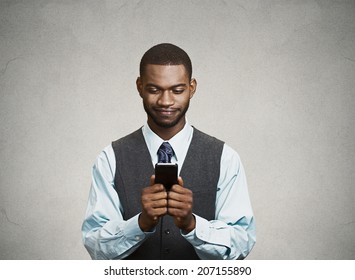 Closeup portrait happy cheerful, young adult business man, excited by what he sees on his cell phone isolated black background. Positive human emotion facial expression, feeling reaction body language - Powered by Shutterstock