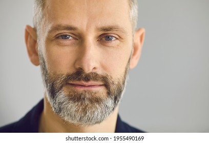 Closeup Portrait Of Happy Confident Attractive Senior European Business Man With Beard, Moustache And Friendly Face Expression On Grey Studio Background. Head Shot Of Mature Client For Testimonial