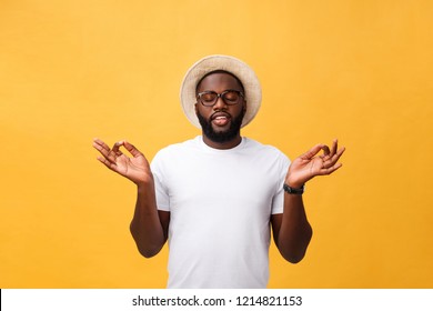 Closeup portrait of happy handsome, young man in meditation yoga mode, isolated on yellow background. Stress relief techniques concept.