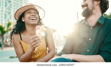 Closeup portrait of happy interracial couple eating ice cream in urban city background. Close-up of a man and woman tasting ice cream. Backlight - Powered by Shutterstock