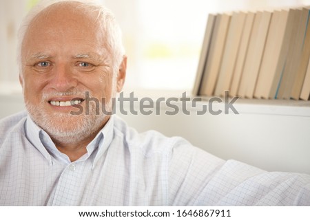 Closeup portrait of happy pensioner smiling at camera.