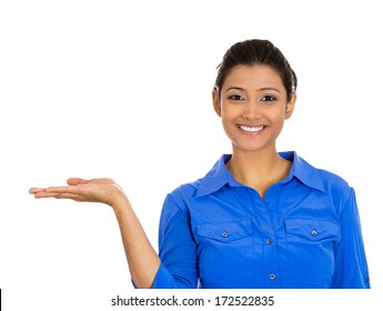 Closeup portrait happy pretty confident young smiling woman gesturing, presenting space at left with palm up isolated white background. Positive human emotion signs symbol, facial expression feelings