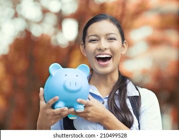 Closeup Portrait Happy, Smiling Business Woman, Bank Employee Holding Piggy Bank, Isolated Outdoors Indian Autumn Background. Financial Savings, Banking Concept. Positive Emotions, Face Expressions