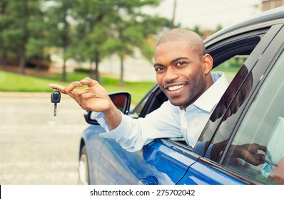 Closeup Portrait Happy, Smiling, Young Man, Buyer Sitting In His New Blue Car Showing Keys Isolated Outside Dealer, Dealership Lot, Office. Personal Transportation, Auto Purchase Concept