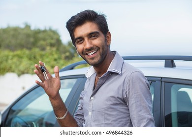 Closeup Portrait Happy, Smiling, Young Man, Buyer Showing Keys Of His New Car Isolated Outside Dealership Lot. Personal Transportation, Auto Purchase Concept