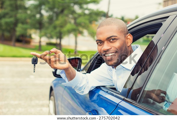 Closeup\
portrait happy, smiling, young man, buyer sitting in his new blue\
car showing keys isolated outside dealer, dealership lot, office.\
Personal transportation, auto purchase\
concept