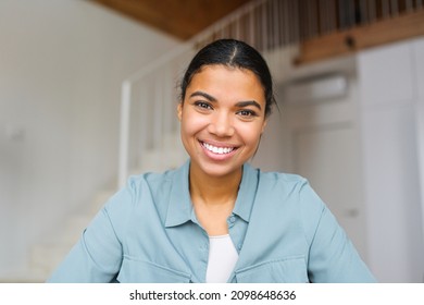 Close-up portrait of happy young woman looking at the camera and smiling. Concept of video call, online communication on the laptop. Webcam view, video chat