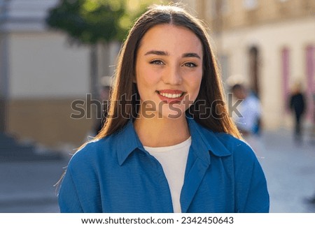 Close-up portrait of happy young woman face smiling friendly, glad expression looking at camera dreaming, resting, relaxation feel satisfied good news outdoors. Pretty girl in urban city sunny street