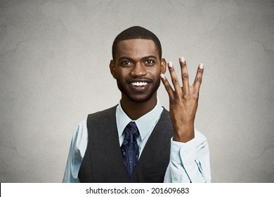 Closeup portrait, headshot, happy, smiling young man making four times sign gesture with hand fingers, isolated black grey background. Positive emotions, facial expressions, feelings, attitude, symbol