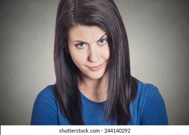 Closeup portrait headshot skeptical young woman looking suspicious with some disgust on her face, mixed with disapproval, isolated grey background. Negative human emotion facial expression feeling