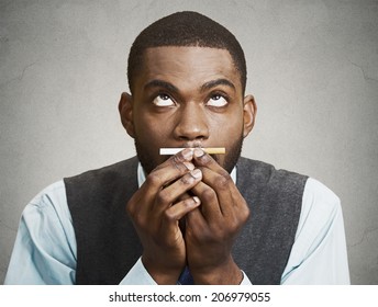 Closeup Portrait, Headshot, Young Handsome Business Man, Corporate Executive, Funny Looking Guy, Craving Cigarette, Tobacco, Isolated Black Grey Background. Bad, Dangerous Human Health Habits Concept