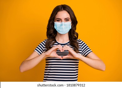 Close-up Portrait Of Her She Attractive Healthy Wavy-haired Girl Wear Safety Gauze Mask Showing Heart Symbol Human Health Insurance Medicare Isolated Bright Vivid Shine Vibrant Yellow Color Background