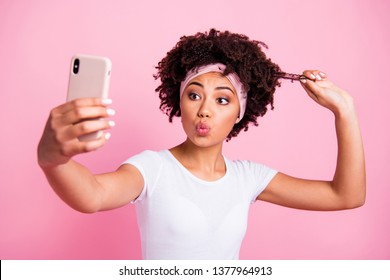 Close-up portrait of her she nice charming cute attractive lovely cheerful cheery wavy-haired girl taking making selfie showing strong curls sending kiss isolated over pink pastel background - Powered by Shutterstock