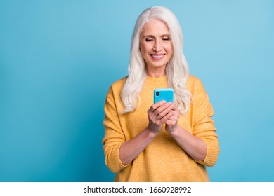 Close-up portrait of her she nice attractive lovely charming pretty winsome cheerful cheery grey-haired woman using device 5g app isolated over bright vivid shine vibrant blue color background - Powered by Shutterstock