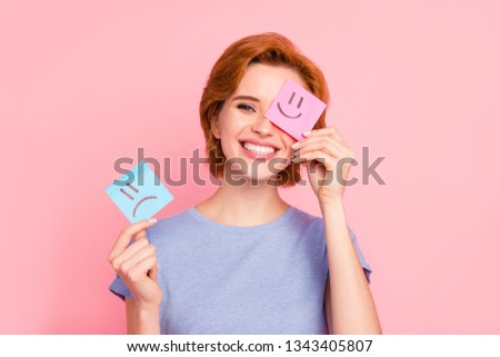 Close-up portrait of her she nice cute charming attractive cheerful girl wearing casual blue t-shirt holding in hands two draw notes positive good choice isolated on pink pastel background