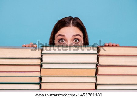 Close-up portrait of her she nice attractive intellectual smart clever brainy stunned girl hiding behind book shelf at work place station isolated over bright vivid shine blue background