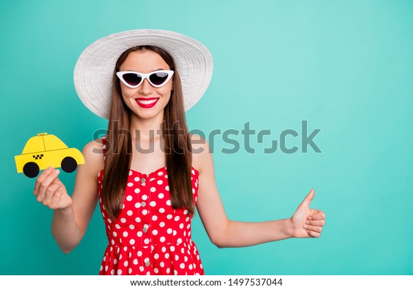 Close-up portrait of her she nice attractive\
cheerful straight-haired girl holding in hand yellow vintage car\
card ask stop life style isolated over green blue turquoise bright\
vivid shine background