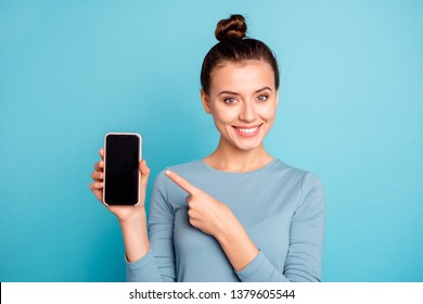 Close-up portrait of her she nice-looking attractive sweet lovely cheerful teenage girl holding in hand new cool buying purchase ad advert isolated over bright vivid shine turquoise background