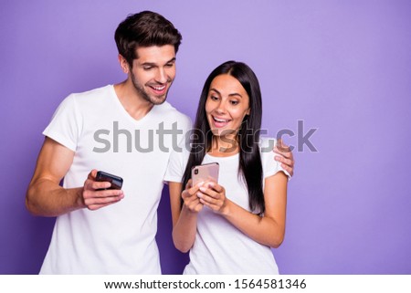 Close-up portrait of his he her she nice attractive lovely cheerful cheery glad amazed couple using digital device watching media content isolated on purple violet lilac color pastel background