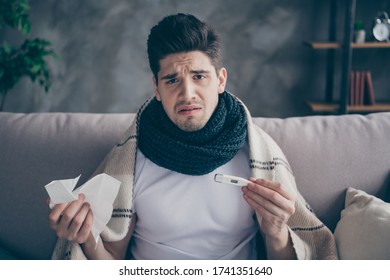 Close-up Portrait Of His He Nice Attractive Sad Ill Guy Sitting On Divan Measuring Temperature Healing Medical Care At Modern Industrial Loft Concrete Interior Style Living-room Indoors