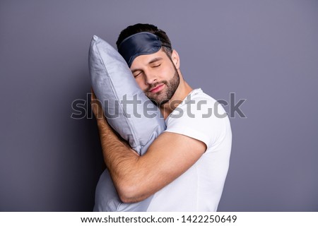 Close-up portrait of his he nice attractive bearded guy holding in hands pillow drowsiness going to bed sleeping quietly calmly isolated over gray pastel violet purple background