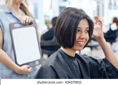 Closeup Portrait Of Hispanic Latin Girl Woman Sitting In Chair In Hair Salon Looking In Mirror At Her New Haircut, Short Bob Pixie, Happy Joy Emotion