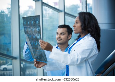 Closeup Portrait Of Intellectual Healthcare Professionals With White Labcoat, Looking At Full Body X-ray Radiographic Image, Ct Scan, Mri, Isolated Hospital Clinic Background. Radiology Department