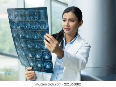 Closeup portrait of intellectual woman healthcare personnel with white labcoat, looking at full body x-ray radiographic image, ct scan, mri, isolated hospital clinic background. Radiology department