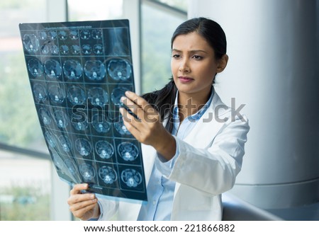 Closeup portrait of intellectual woman healthcare personnel with white labcoat, looking at full body x-ray radiographic image, ct scan, mri, isolated hospital clinic background. Radiology department