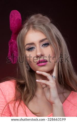 Close-up portrait, isolated, Blonde model looks like Barbie with pink lips and blue eyes with pink bow