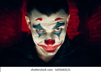 Close-up portrait of a joker man. Stock photo makeup joker in a horror room. - Shutterstock ID 1655643121